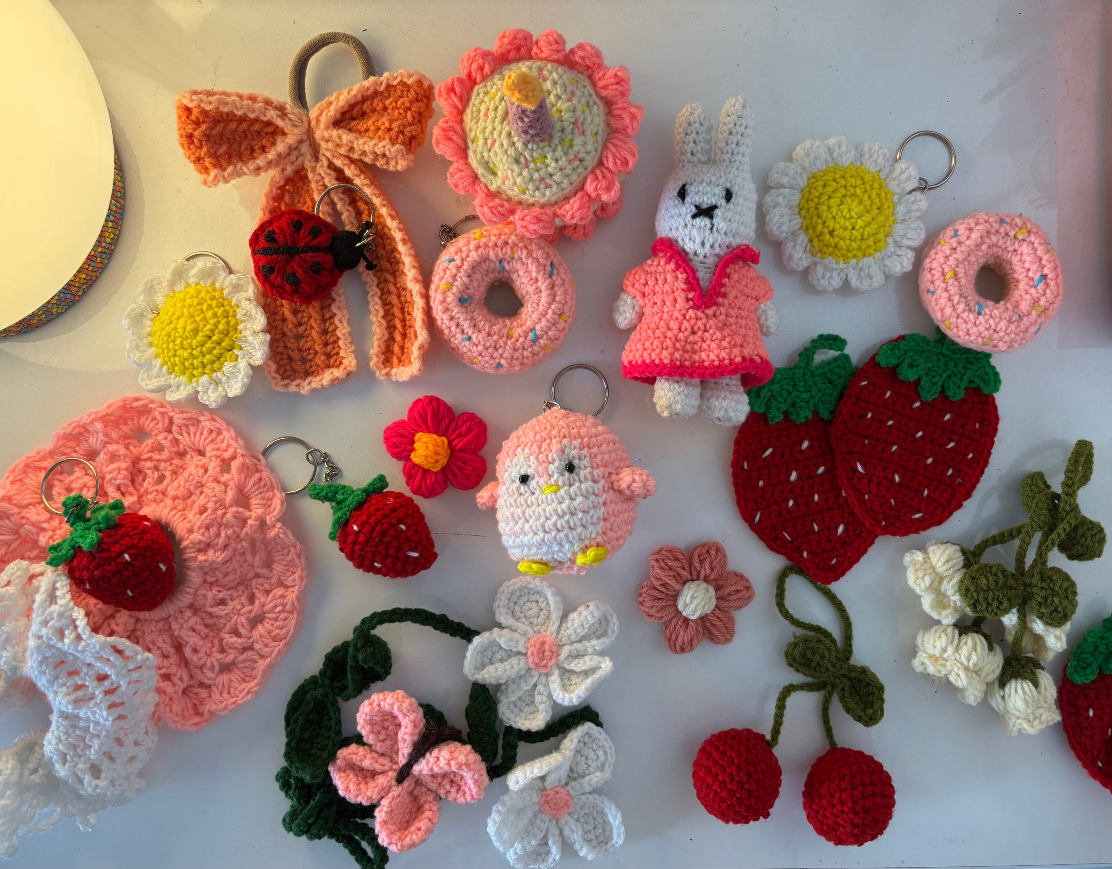 Collection of colorful crochet keychains  and amigurami toys and decorations on a white surface