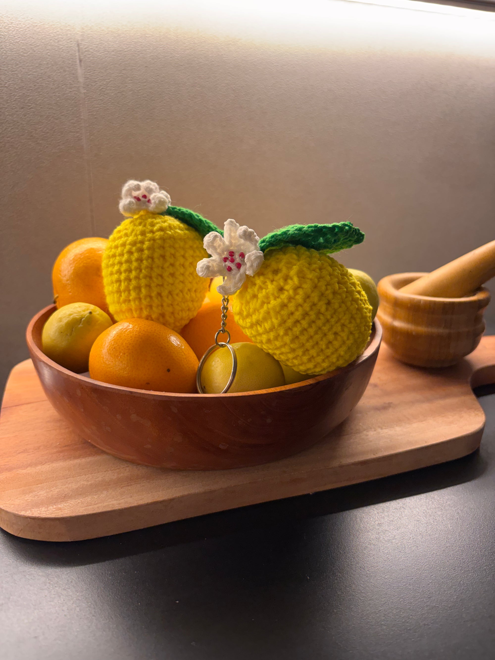 yellow crochet lemon keychain with a white flower and a green leaf