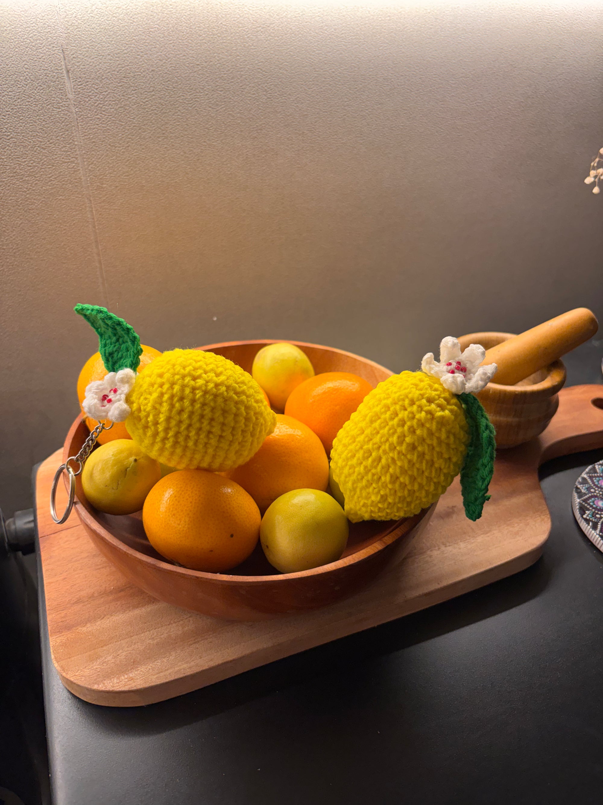 yellow crochet lemon keychain with a white flower and a green leaf