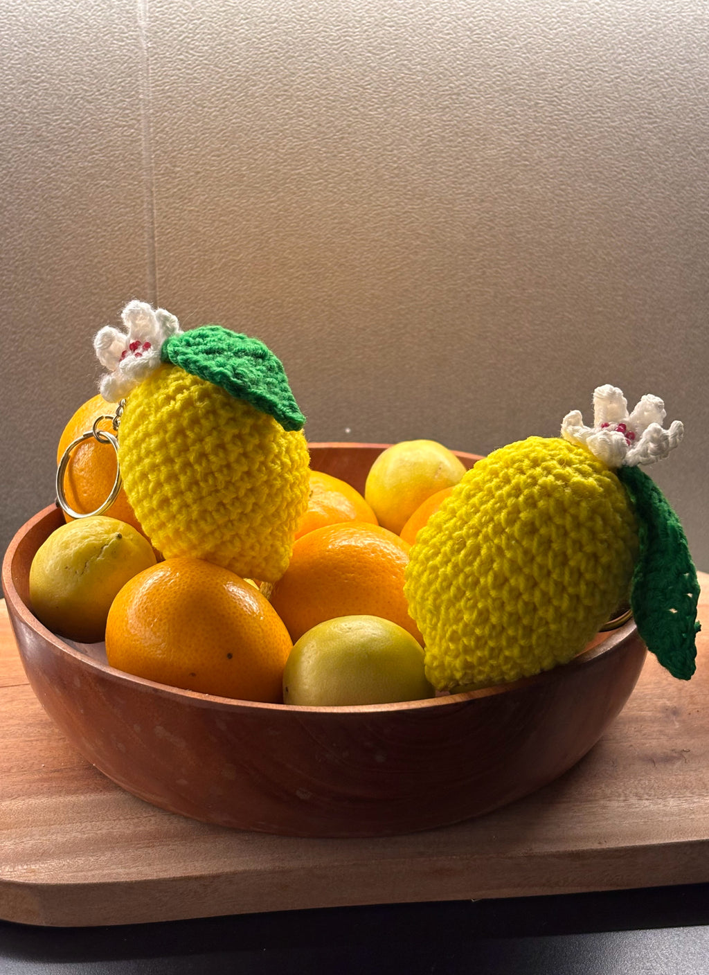 yellow crochet lemon keychain with a white flower and a green leaf