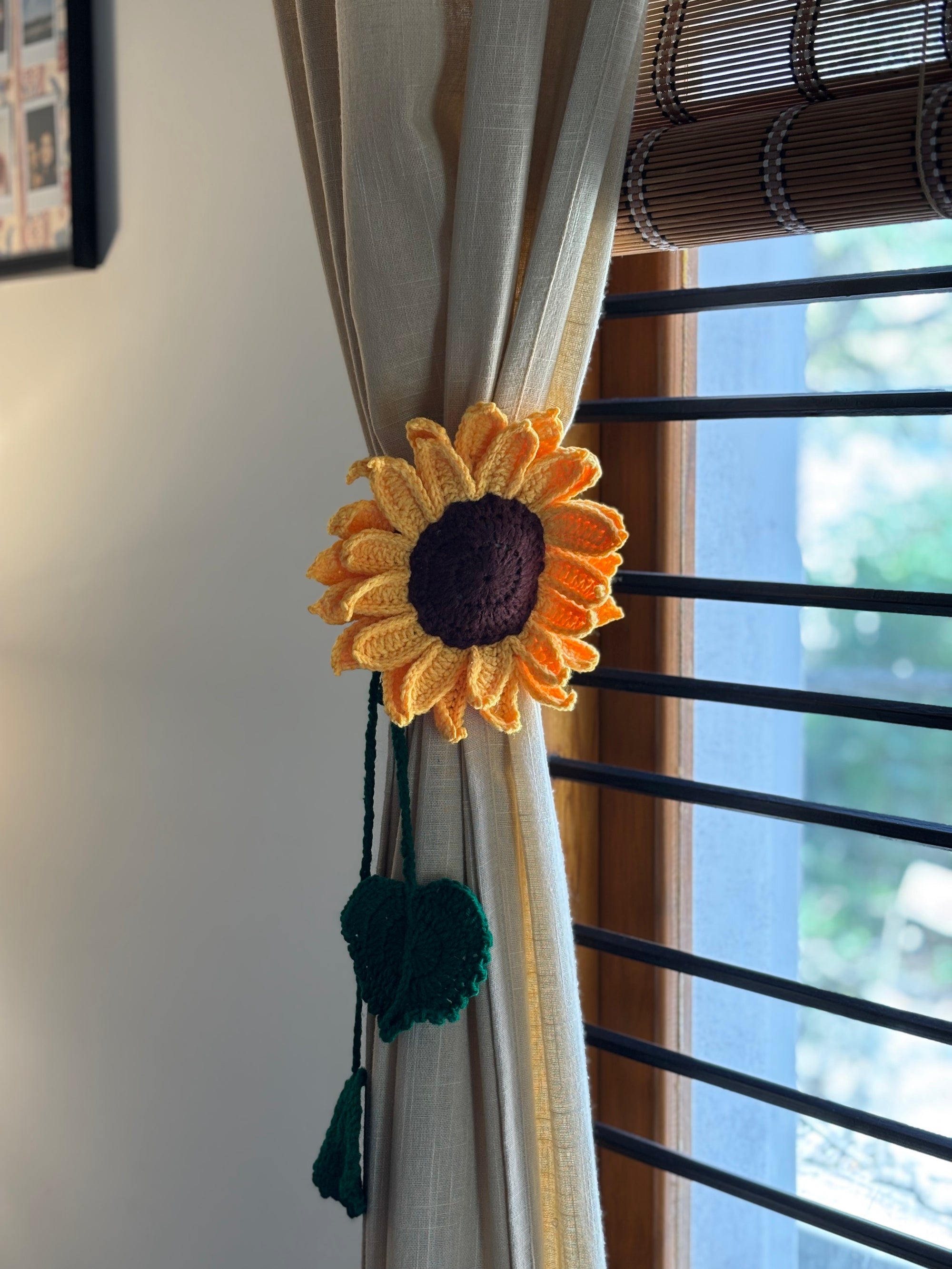 Sunflower-shaped curtain tieback on a beige curtain with a window in the background